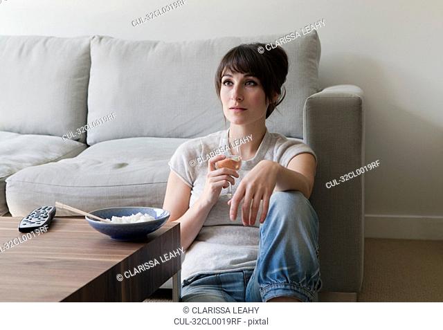 Woman watching television with dinner