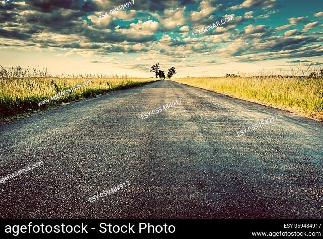 Empty straight long asphalt road. Dramatic cloudy sky. Concepts of travel, adventure, destination, transport etc. Vintage style