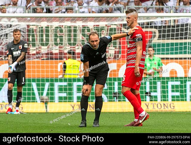 06 August 2022, Bavaria, Augsburg: Soccer, Bundesliga, FC Augsburg - SC Freiburg, Matchday 1, WWK-Arena. Augsburg's Jeffrey Gouweleeuw (r) supports referee...
