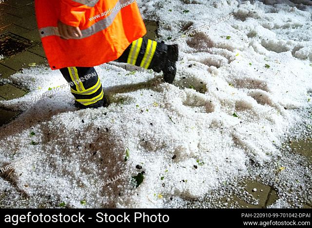 09 September 2022, Mecklenburg-Western Pomerania, Stralsund: Hailstones lie on a street and on the sidewalk in Stralsund