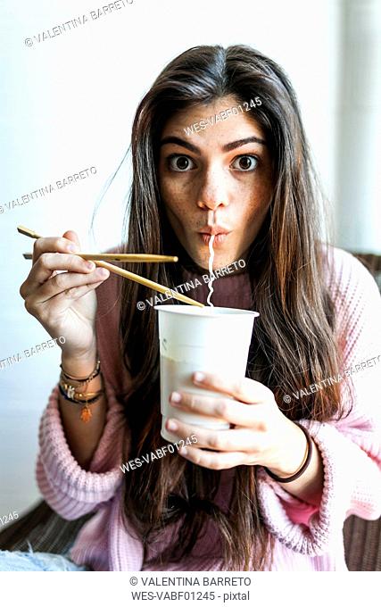 Young woman eating Chinese noodles