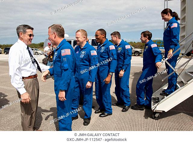 Bob Cabana, director of NASA's Kennedy Space Center in Florida, greets the STS-133 crew members as they exit the crew transport vehicle after landing aboard...