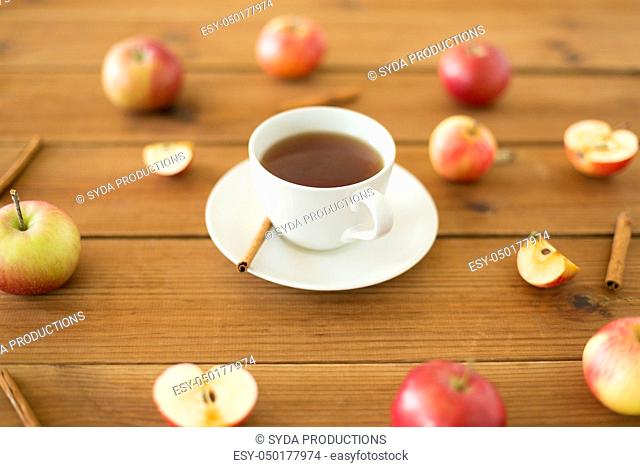 cup of tea with apples and cinnamon on table