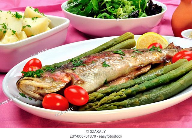 grilled rainbow trout with asparagus on a plate
