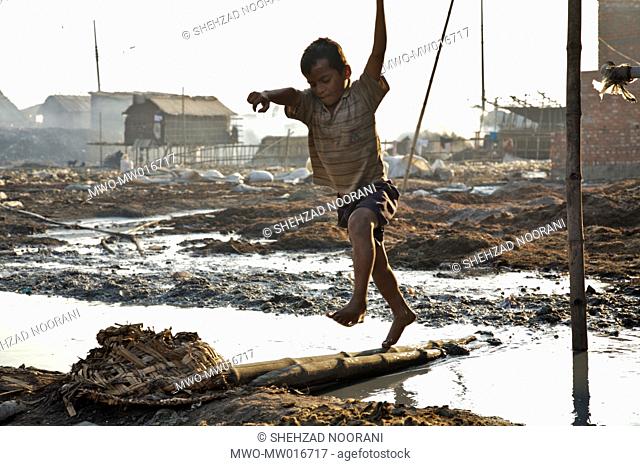 A kid jumps over a puddle of chemical wastes, at a large dumpsite of tanneries, at Hazaribagh, near Buriganga river, in Dhaka Like many other industries...