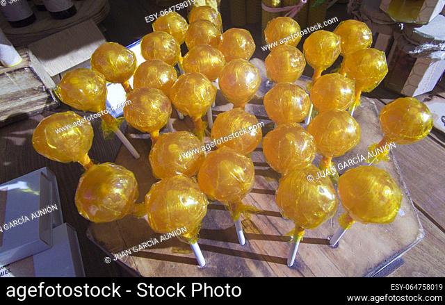 Honey lollipops displayed in a traditional market stall. Healthy candy concept