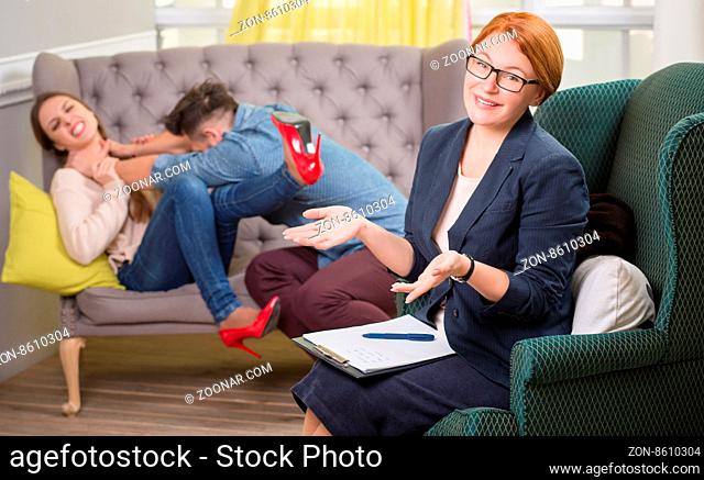 Couple of patients fighting while having a conversation with their psychotherapist on couch in office