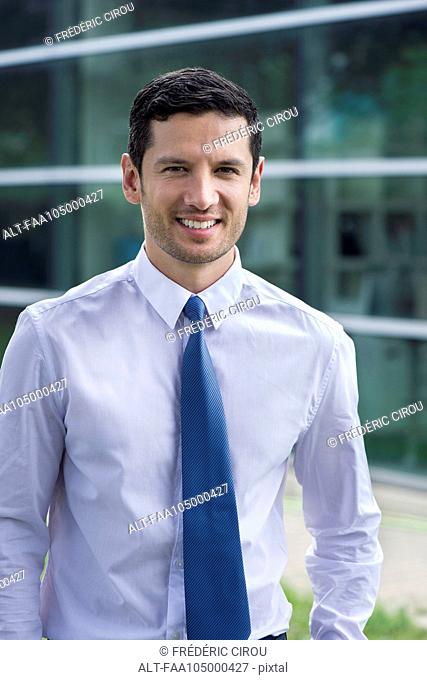 Businessman smiling outdoors, portrait