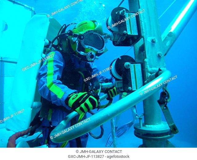 NEEMO 14 crew member Andrew Abercromby operates the small crane on the lander mock-up to retrieve a small payload from the sea floor during an undersea session...
