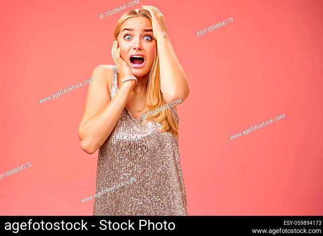 Shocked terrified blond woman horrified see crime screaming pop eyes shouting hold hands head afraid trembling fear standing frightened drop jaw gasping face...