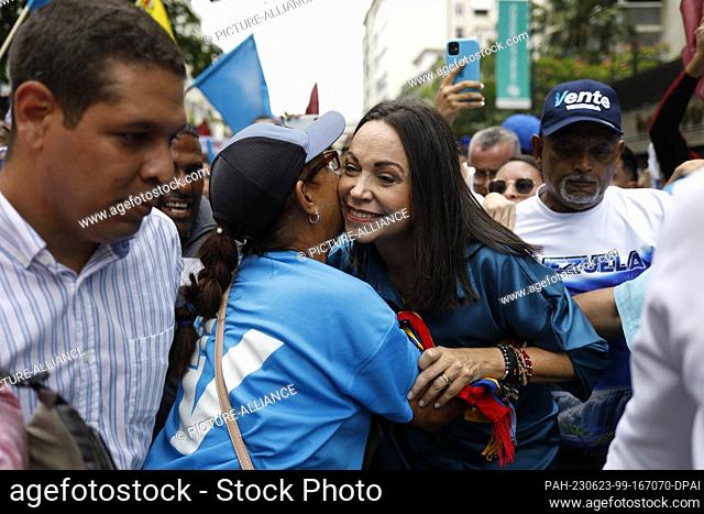 23 June 2023, Venezuela, Caracas: Corina Machado (M) greets a supporter as she arrives surrounded by supporters at Plaza Altamira for the announcement of her...