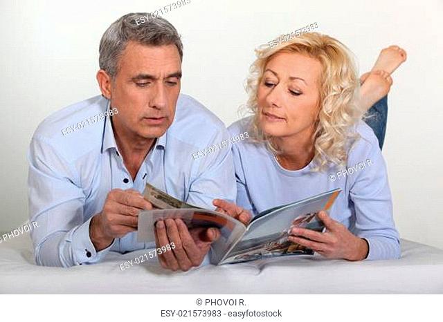 Middle-aged couple leafing through a brochure