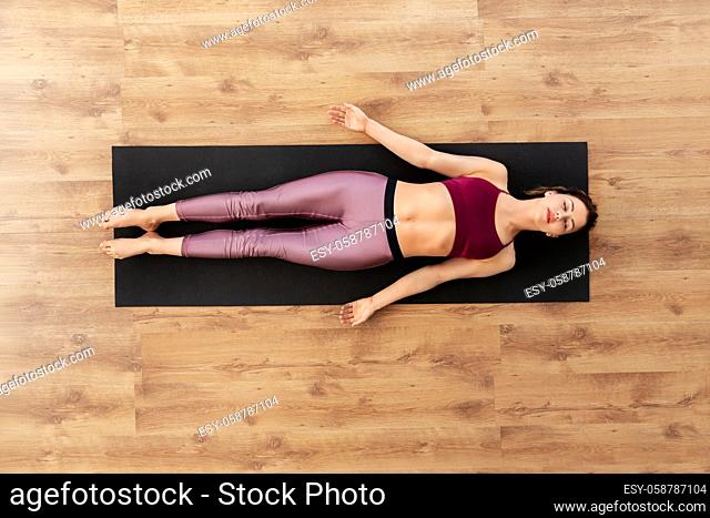 woman doing yoga corpse pose at studio