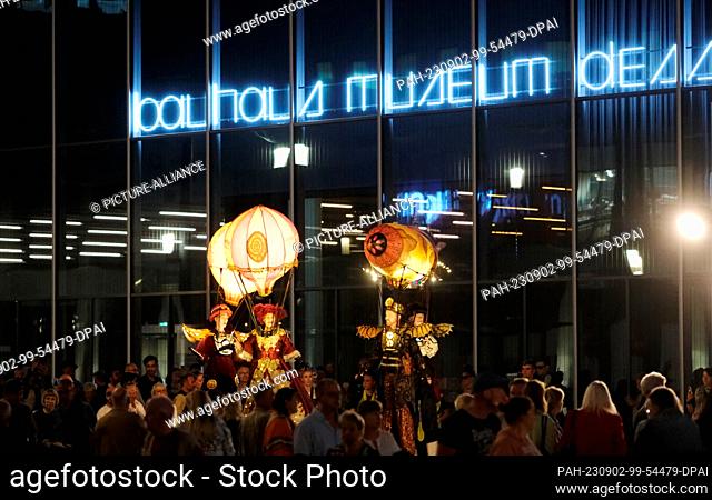 02 September 2023, Saxony-Anhalt, Dessau-Roßlau: Participants in a parade stand on stilts at the Bauhaus Museum. The two-day Bauhaus festival will feature...