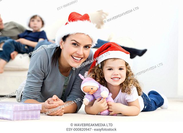 Happy mother and daughter at christmas lying on the floor at home