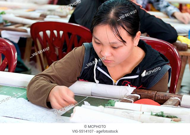 Woman sewing factory labor work making tedious handmade items in Hanoi Vietnam - 06/11/2015
