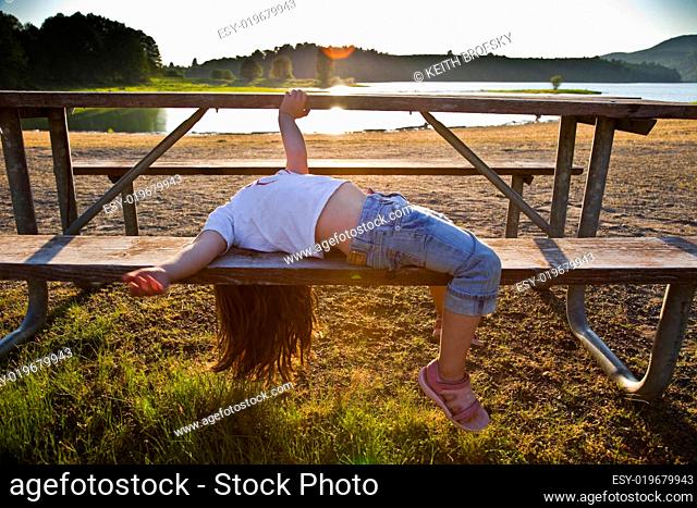 Girl Lying on Picnic Table Bench