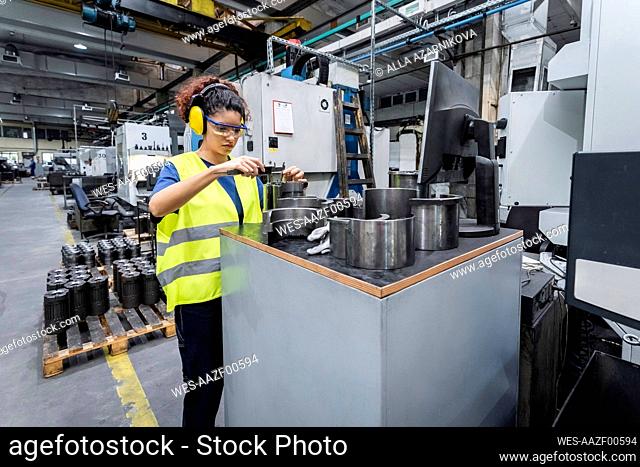 Maintenance engineer in reflective clothing working in modern manufacturing industry
