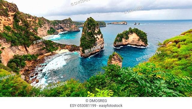 Sea coast view with little house standing on the high cliff bring above sea and little rocky islets. Atun beach, Nusa Penida island