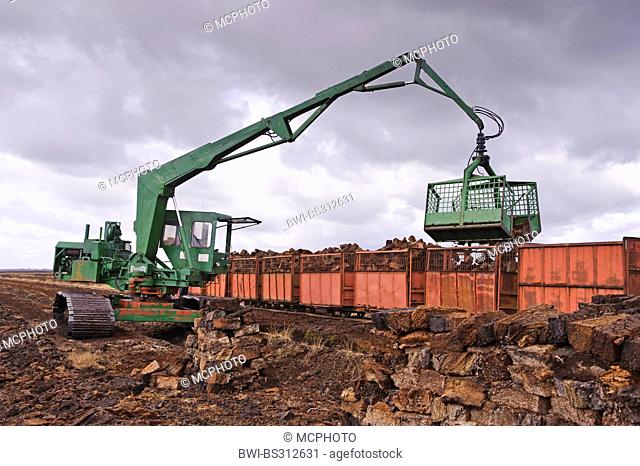 moor railway being loaded with bales of peat with the help of an excavator, Germany, Lower Saxony, Goldenstedt