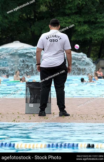 23 June 2021, Berlin: An employee of the security service ""Security GSO"" stands at the edge of the pool in the Prinzenbad