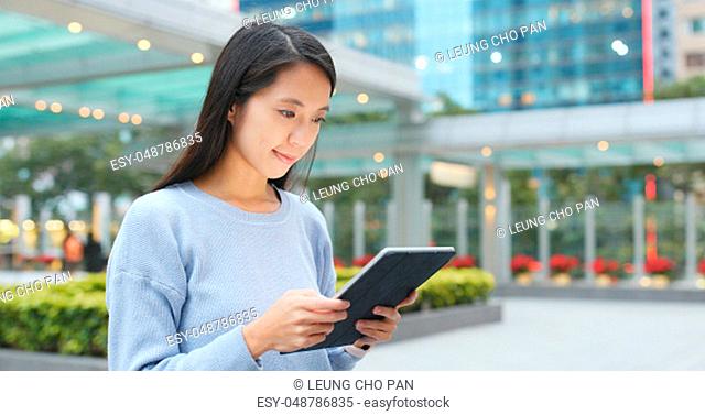 Asian woman working on tablet computer at outdoor