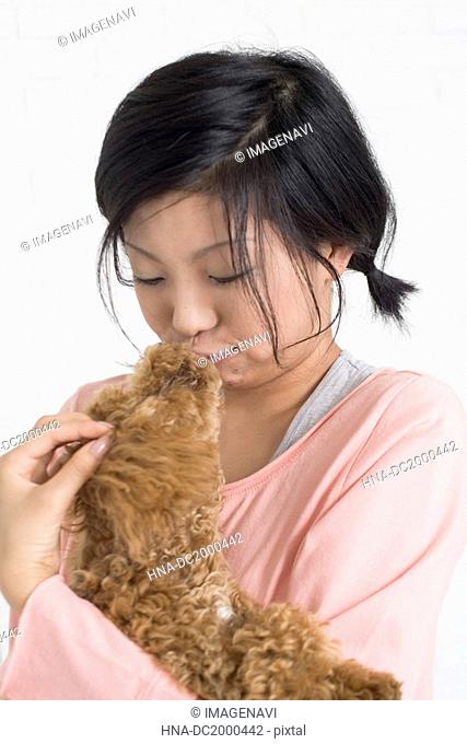 Young woman kissing pet dog