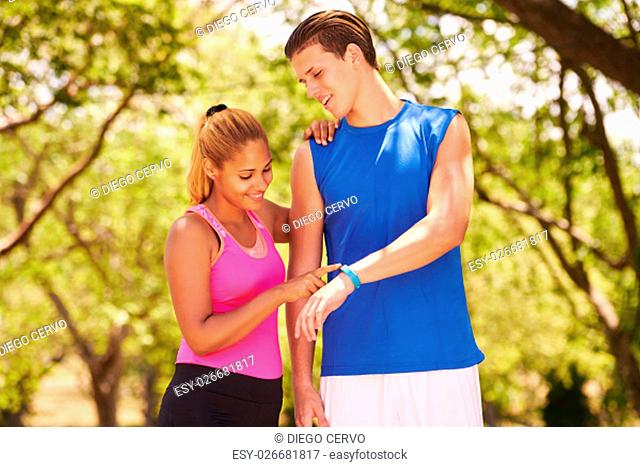 Young people doing sport activities, girl and friend running, man and woman using fit watch. Concept of eisure, health, recreation, fitness, exercising