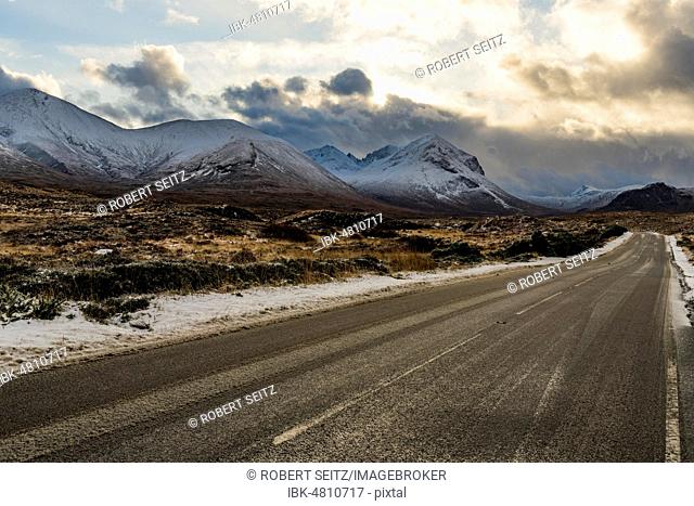 Snowy mountain tops of Ben Lee with clouds in Highland landscape and road cup in the foreground, Sligachan, Portree, Isle of Sky, Scotland, United Kingdom