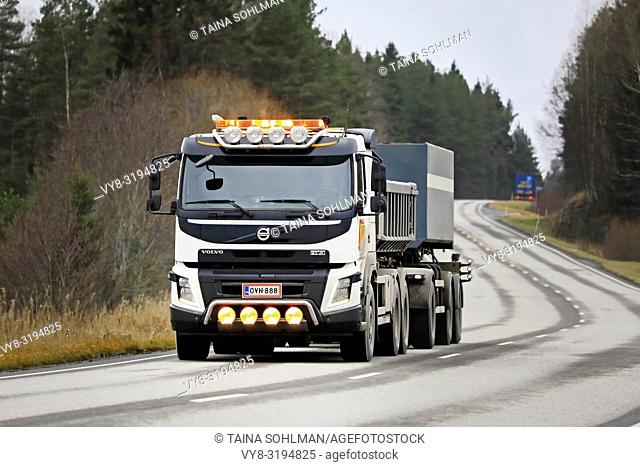 Salo, Finland - November 9, 2018: White Volvo FMX gravel truck hauling a load on highway with auxiliary lights on a rainy day in South of Finland