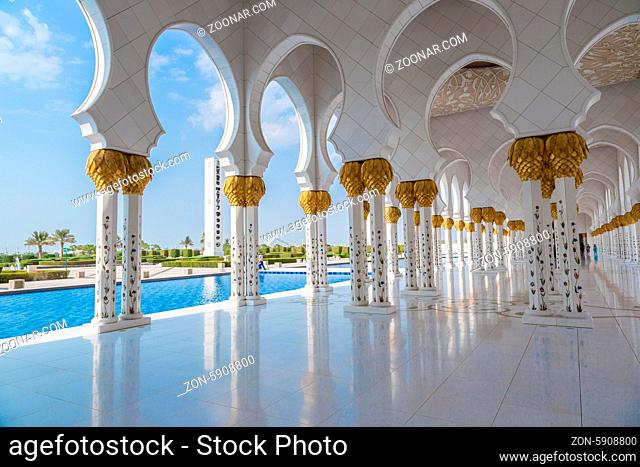 ABU DHABI, UAE - JUNE 11: The Sheikh Zayed Grand Mosque, muslims and tourists on June 11, 2013 in Abu Dhabi, UAE. It is the largest mosque in UAE and eighth...