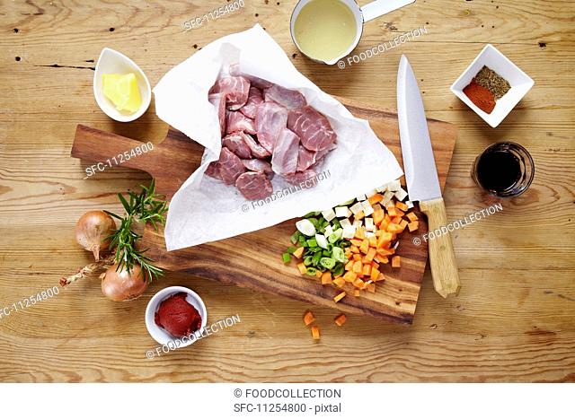 Raw pork cheeks with ingredients on a wooden table