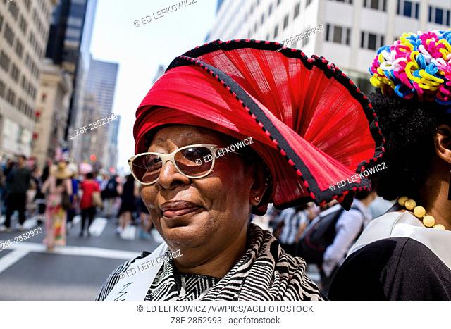 New York, NY - April 16, 2017. A woman from The Milliners Guild wearing a red a black hat at New York's annual Easter Bonnet Parade and Festival on Fifth Avenue
