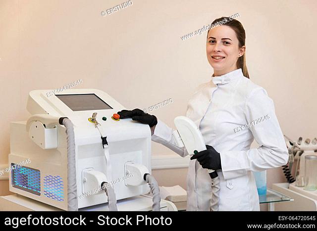 female cosmetologist doctor with laser, hair removal with modern equipment