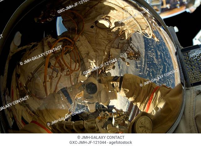 Russian cosmonaut Oleg Kotov, Expedition 22 flight engineer, uses a digital still camera to expose a photo of his helmet visor during a session of...