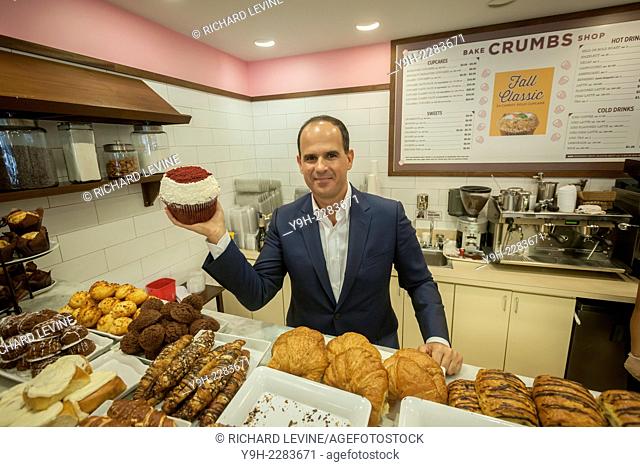 Co-owner Marcus Lemonis poses with a giant cupcake in the Crumbs Bake Shop in the Garment District in New York on its grand re-opening day, Tuesday, October 14