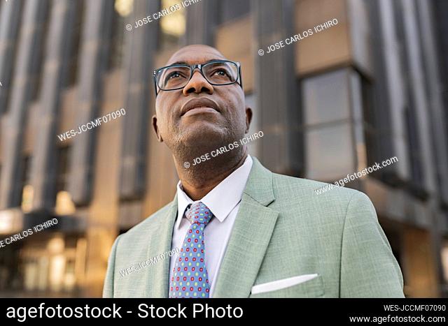 Mature businessman standing in front of building