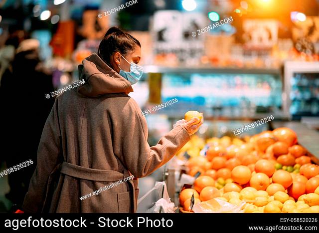 Young woman in protective mask makes purchases in the supermarket