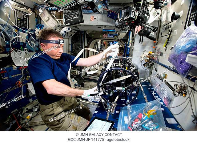 NASA astronaut Terry Virts prepares the Multi-user Droplet Combustion Apparatus from inside the Combustion Integrated Rack for upcoming runs of the FLame...