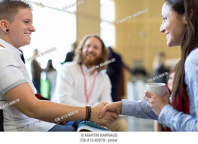 Businesswomen shaking hands at conference