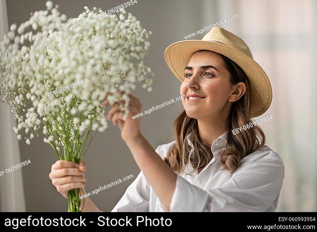 happy woman holding gypsophila flowers at studio