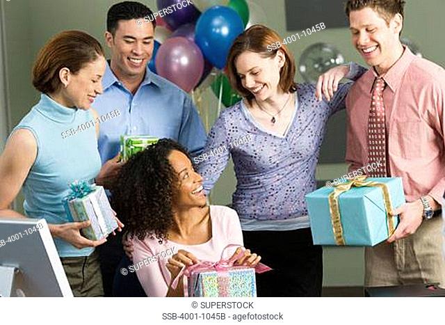 Business executives celebrating birthday party of their colleague in an office