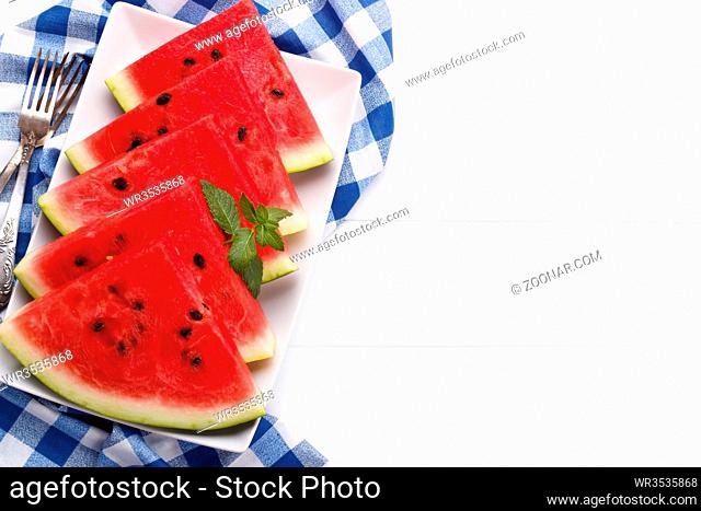 Sliced, juicy watermelon and mint overhead view on a plate. copy space for text