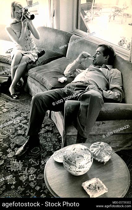 Italian actor Ugo Tognazzi filmed while smoking and lying on the couch. 1960s