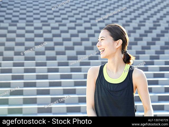Young Japanese Woman Taking A Break During Jogging