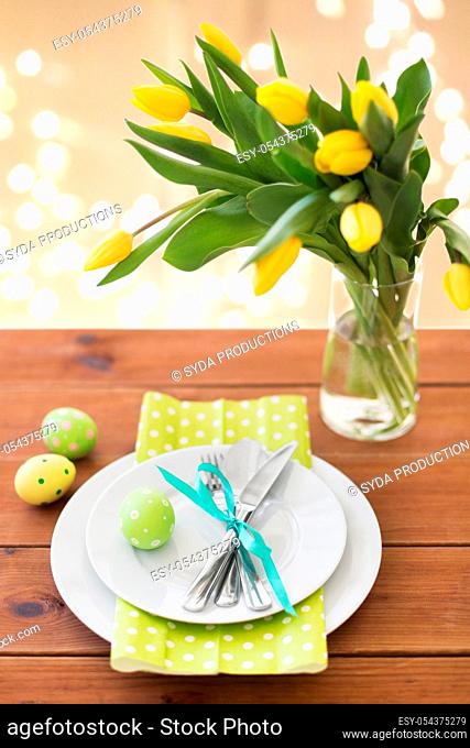easter egg, plates, cutlery and tulip flowers