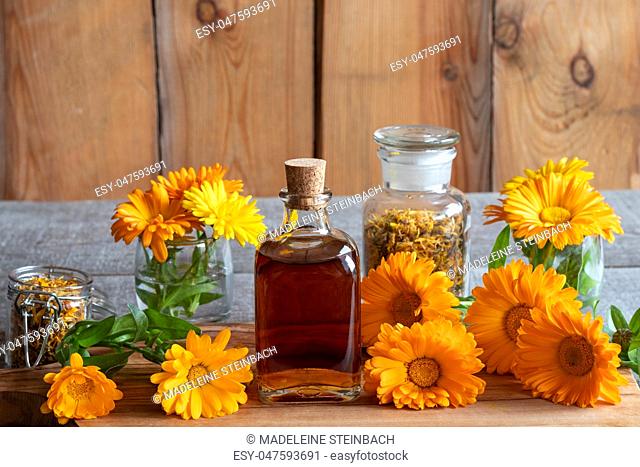 A bottle of calendula tincture with fresh flowers