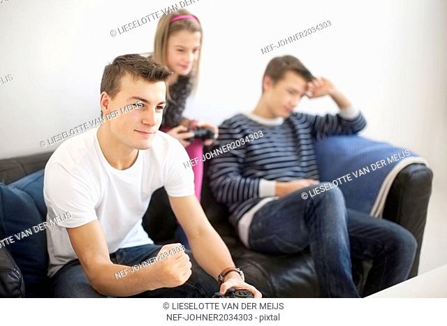 Children on sofa playing video game