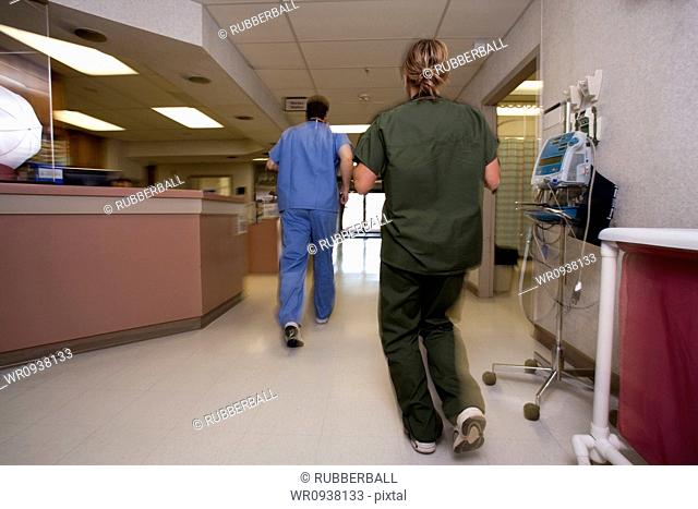 Doctor and nurse running in corridor from behind