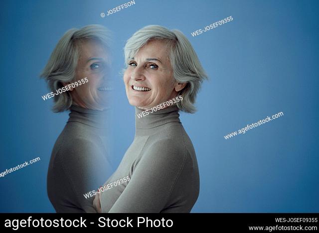 Multiple exposure of senior woman against blue background